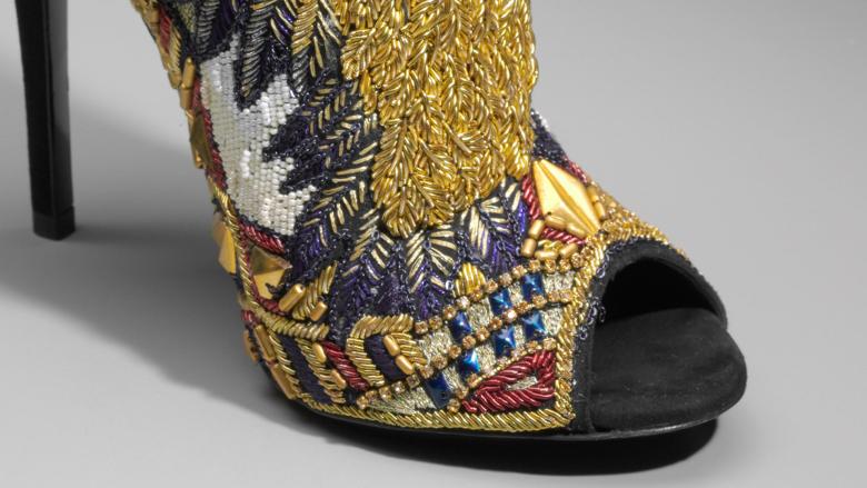 Close-up of high-heeled shoes decorated with yellow beads.
