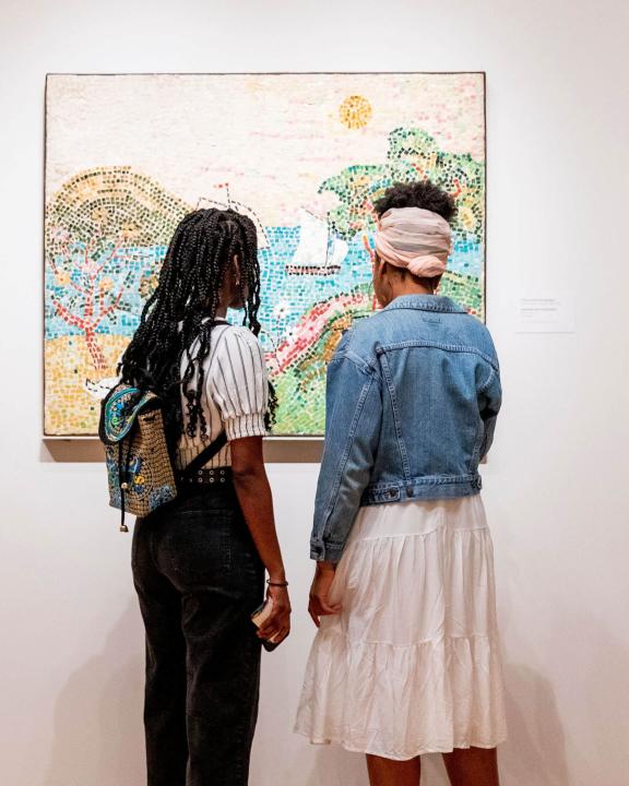Two visitors looking at painting in an Art of the Americas gallery