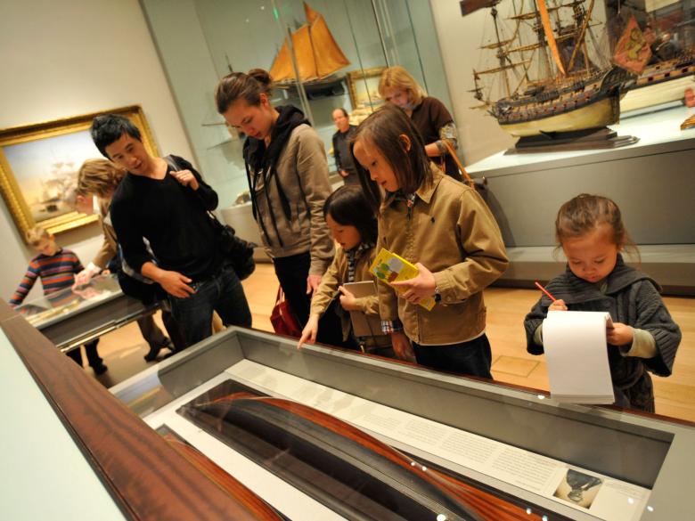 Family looking inside drawer in model ship gallery