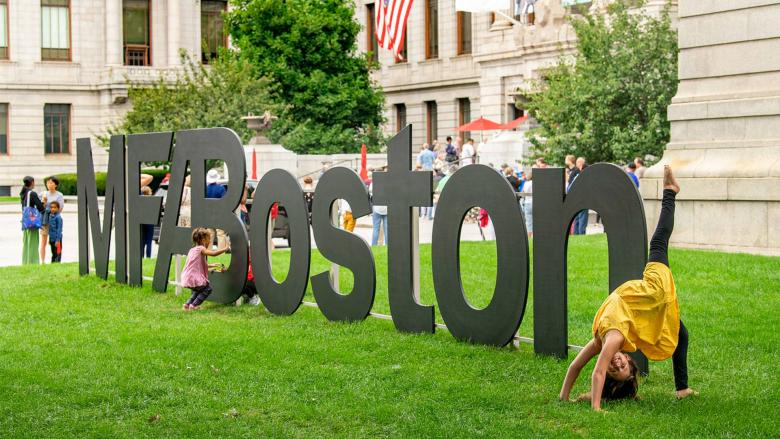 Visitors explore the MFABoston logo sign on the Huntington lawn