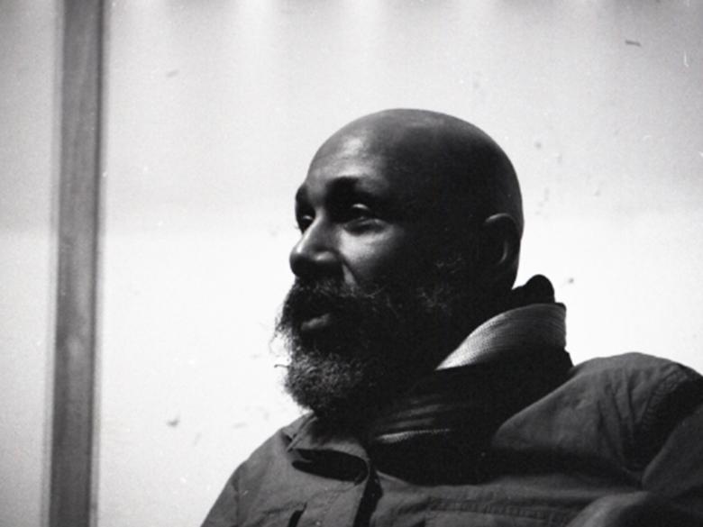 Black-and-white photo of a bearded man in dramatic light.