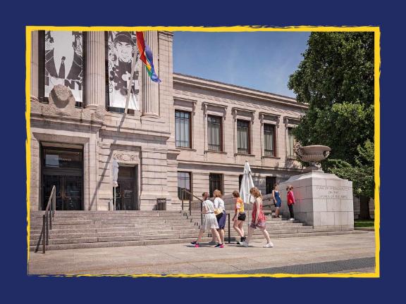 Four young visitors walking up the steps at the entrance of the Museum