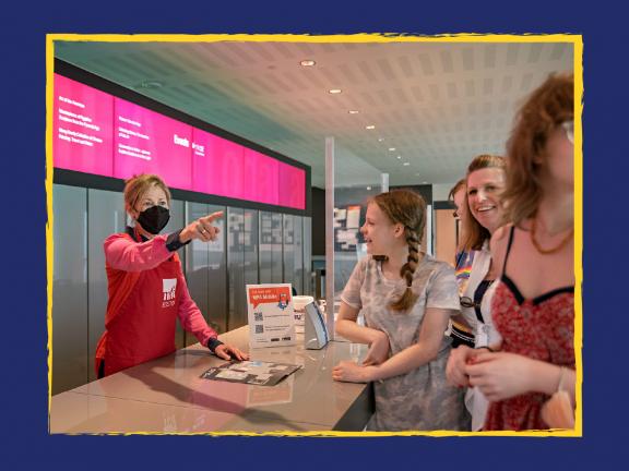 Museum staff giving directions to four visitors in Sharf Visitor Center