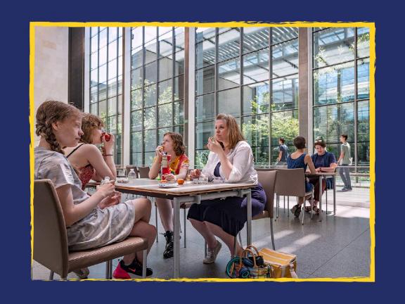 Four visitors sitting and eating at at table