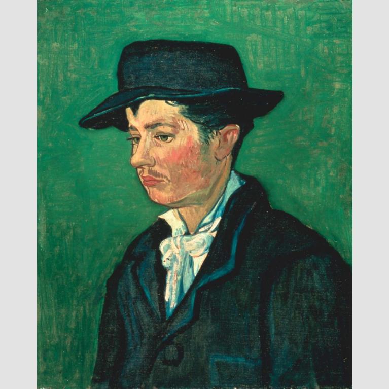 Profile of a man in a yellow jacket, black waistcoat, a tie and a black fedora hat.