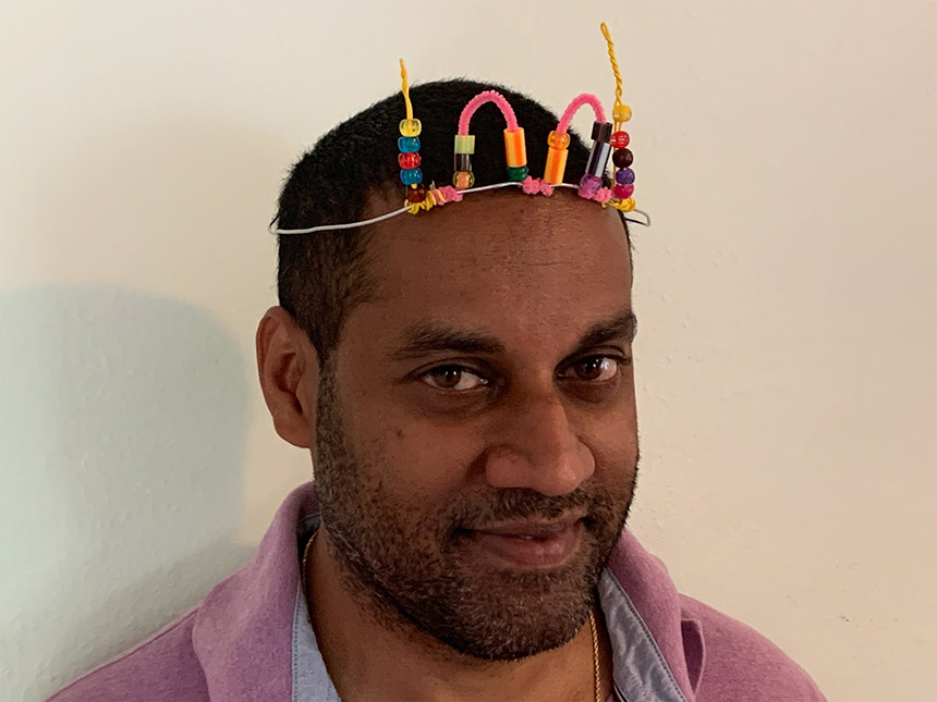 man wearing finished crown made of aluminum wire and pipe cleaner with beads