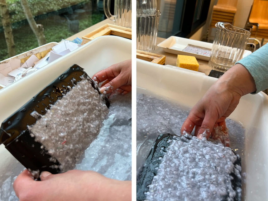holding the mould at an angle, and dipping it into the bin to scoop up paper pulp onto the screen of the mould