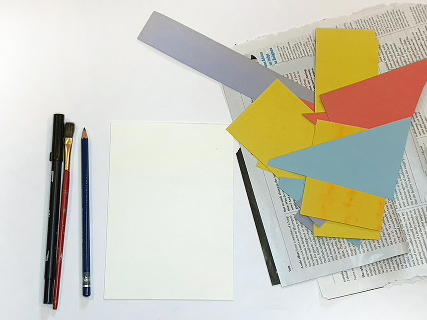 Arrangement of pen, pencil, paintbrush, and pieces of construction paper and newspaper