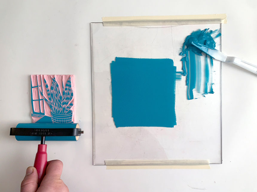 applying paint onto relief block using brayer