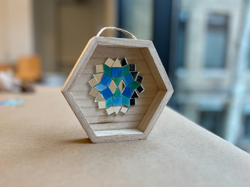 mosaic of geometric shapes of various colors arranged in a pattern inside a small wooden box