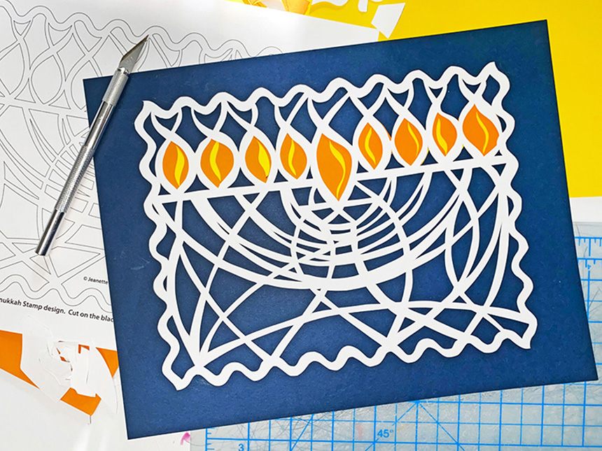 elaborate paper cut-out of Hanukkiah based on 2022 USPS Hanukkah stamp design