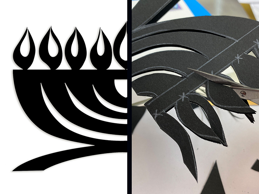 using scissors to cut out the Hanukkiah based on the drawn lines on the black paper