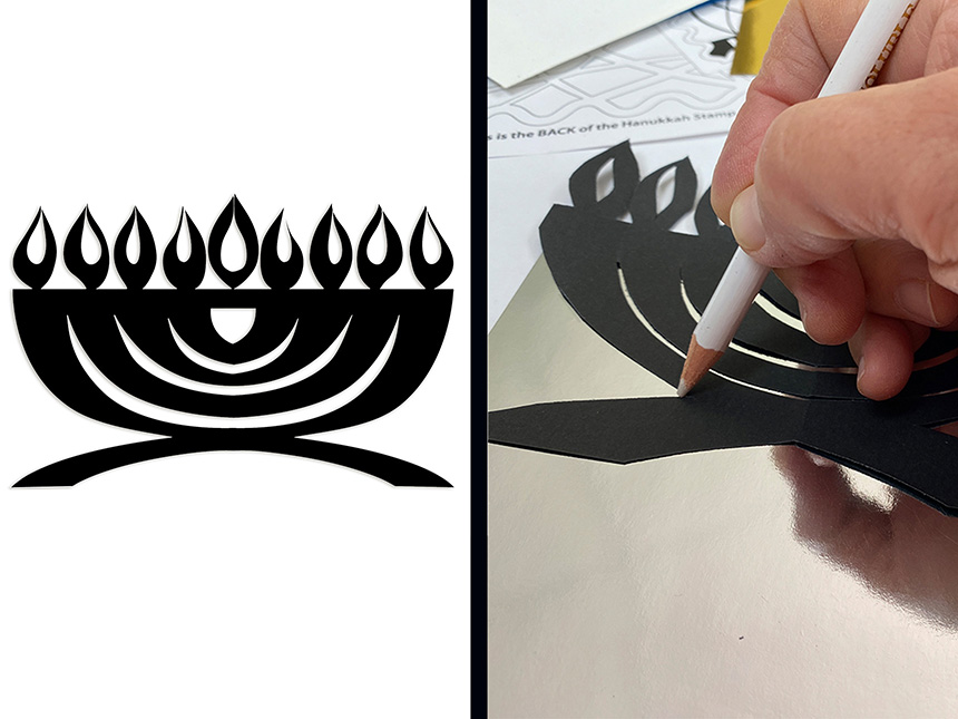 tracing the outline of the Hanukkiah onto the silver paper using white pencil