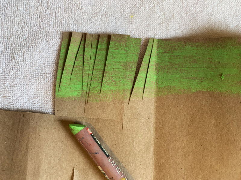 coloring extra paper green and cut in fringes that resemble grass