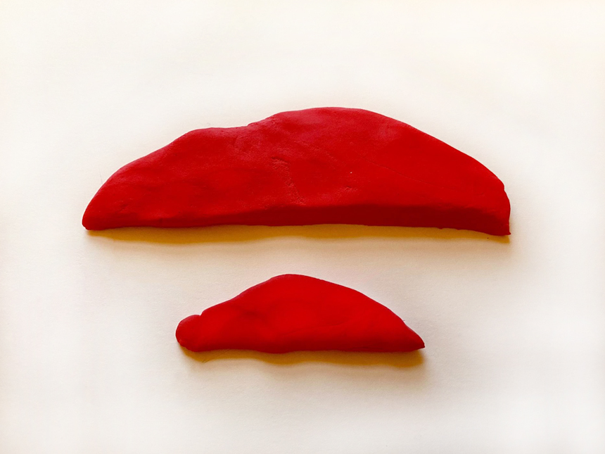 two differently sized half-oval shapes made of the same colored clay