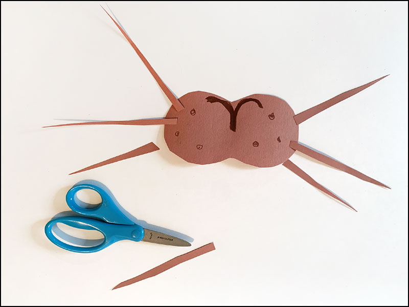 scissors next to pieces of construction paper cut to the shape of snout