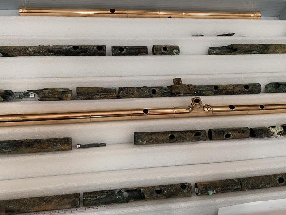 Reassembled original pipes next to bronze reproductions