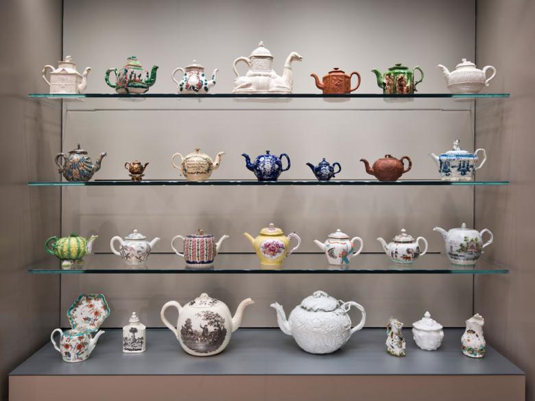 View of display case filled with a variety of ceramic British teapots