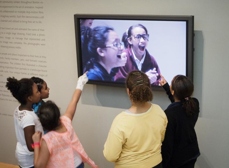 Kids pointing at screen in Community Arts Initiative installation