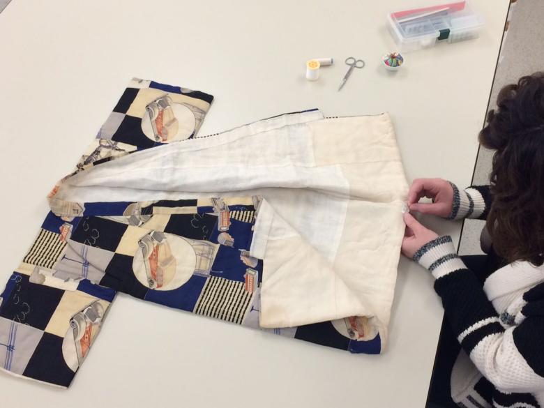 Sewing of the object label on a child’s kimono