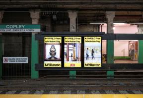 Triptych of three digital ads visible across trolley tracks at Copley station