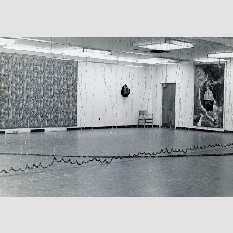 The "5+1" gallery space is split by a barbed wire curtain.