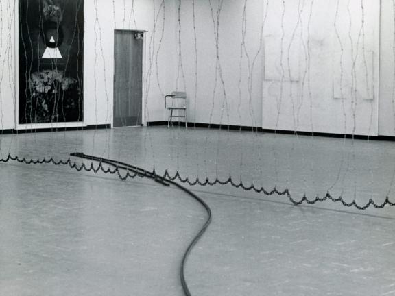 A cord travels across a floor and ends in a coiled circle. 