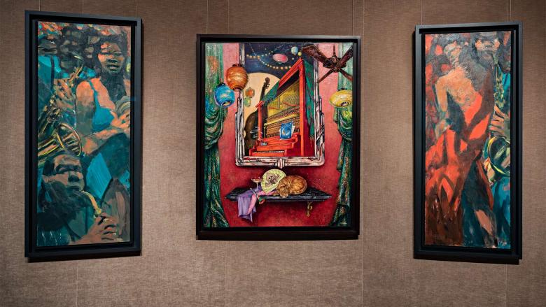 three paintings hanging on wall, each depicting scenes of musicians performing
