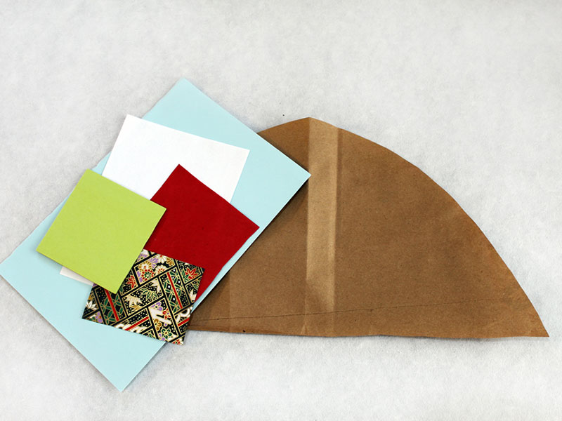 pieces of colors paper on top of cut paper bag