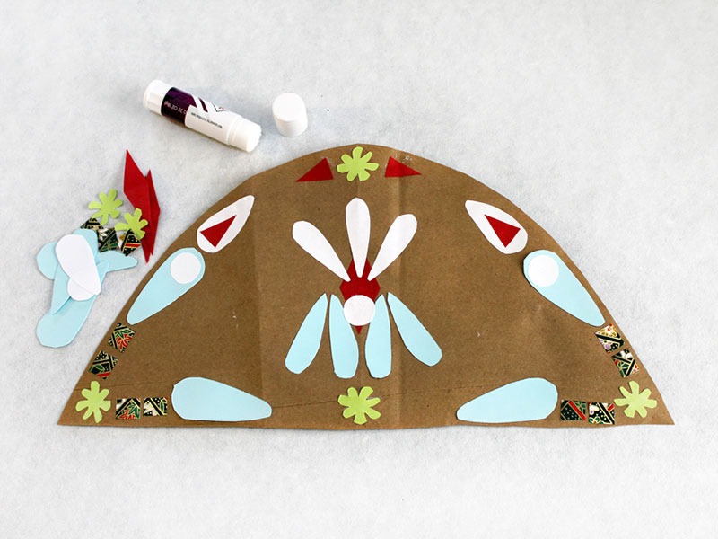 colored paper cut-outs arranged and glued onto paper bag