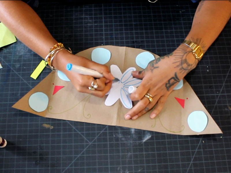 person drawing on colored paper with marker