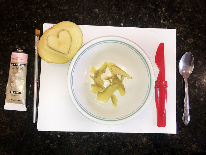 potato bits in bowl, shaved from adjacent potato