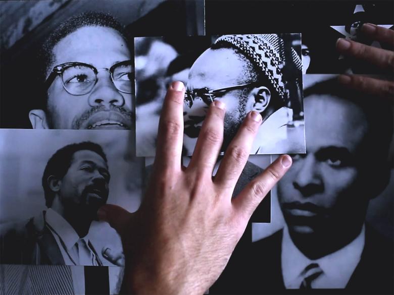 A hand covers photographs of various activists and civil rights leaders.