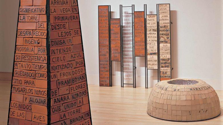 Brick obelisk, brick dome, and brick panels with writing in Spanish on them.