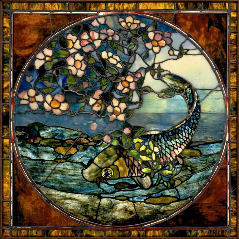 A leaded and stained glass image of a fish wrapped in pink flowers. 