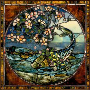 A leaded and stained glass image of a fish wrapped in pink flowers. 