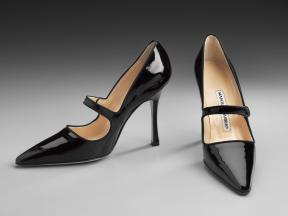 A pair of black patent Mary Jane heels with a pointed toe. 