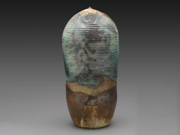 A tall and lean stoneware vessel with a gray-blue glaze.