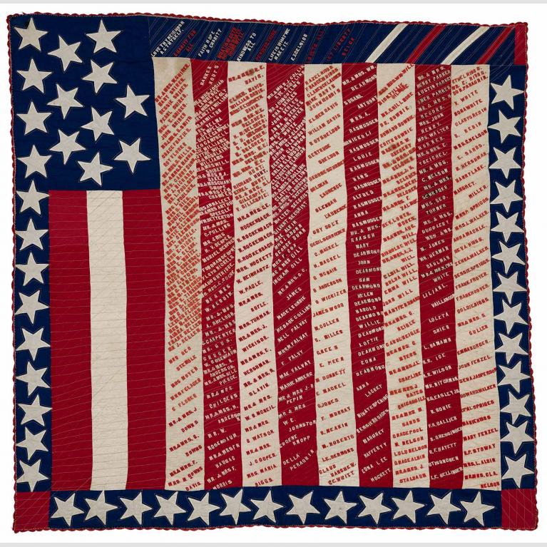 Red, white and blue quilt with stars, stripes and text