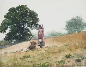 A boy lies in a field while a girl stands next to him.