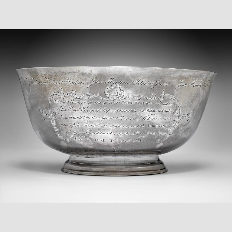 A silver bowl against a gray backdrop.
