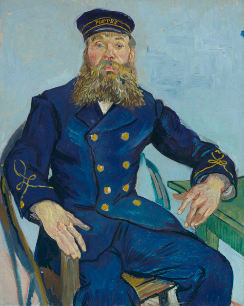 A bearded postman wearing a blue uniform sits on a chair with his arm resting on the edge of a table.