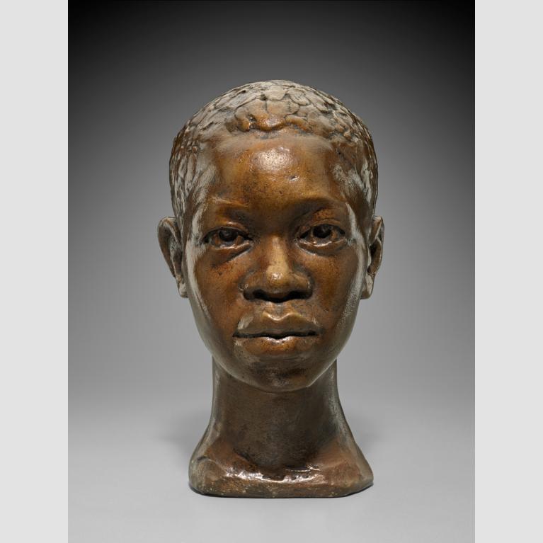 Plaster bust of a young Black man looking straight ahead with a reserved expression.