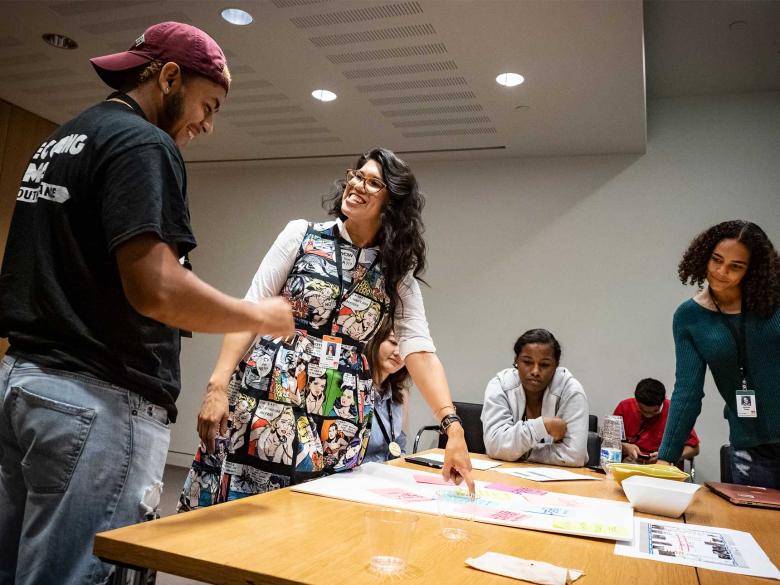 curator discussing project with teens around table
