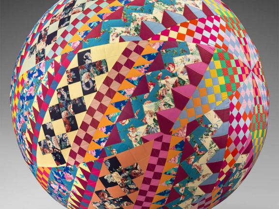 A multi-colored quilt wrapped around a spherical ball