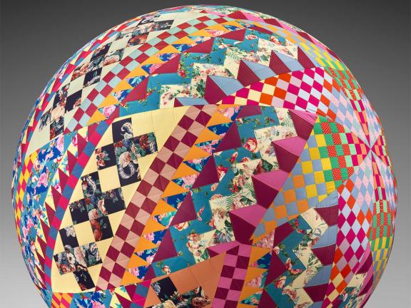 detail of multi-colored quilt wrapped around a spherical ball