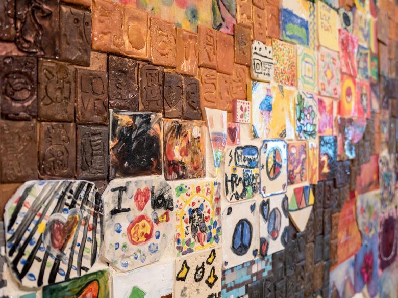 detail of multicolored relief sculpture made up of smaller works of art created by grade school students