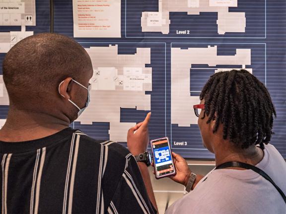 Two visitors looking at the large wall map in Sharf Visitor Center