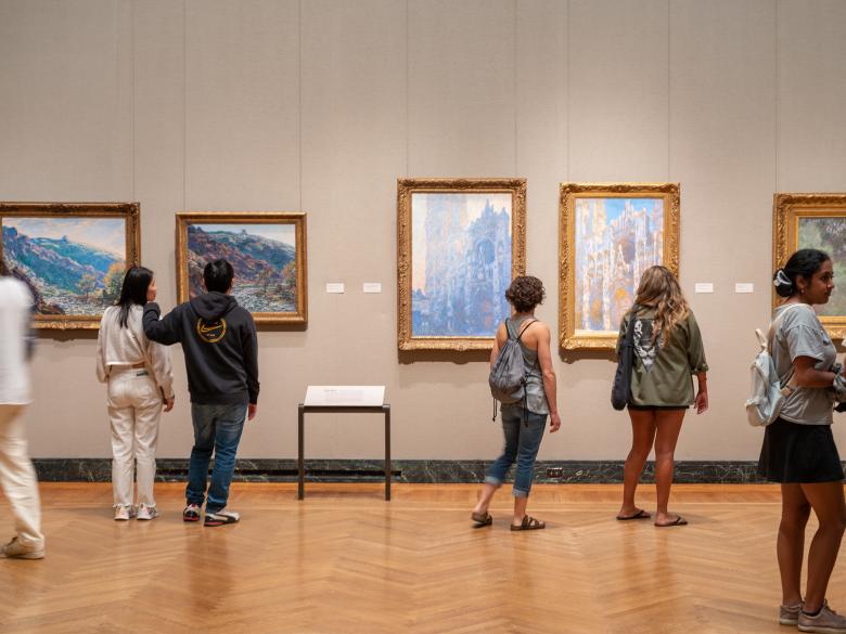 Visitors looking at various Monet paintings hanging in the Impressionism gallery