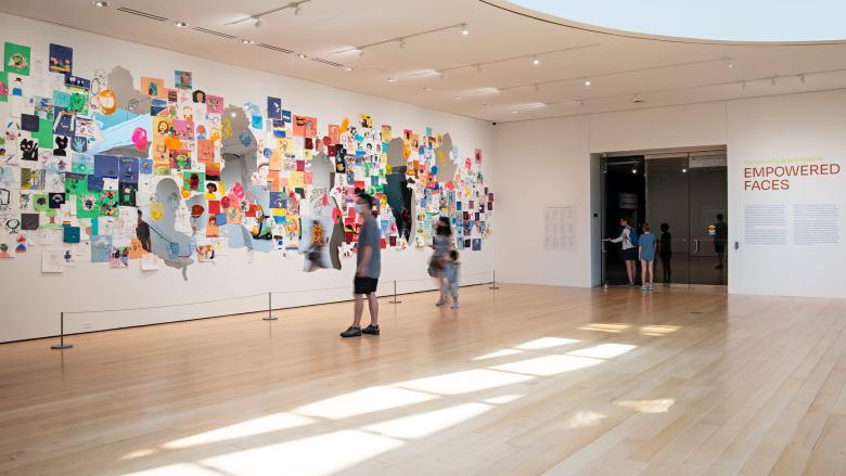 Museum visitors admiring the artwork of the Community Arts Initiative: Empowered Faces exhibition